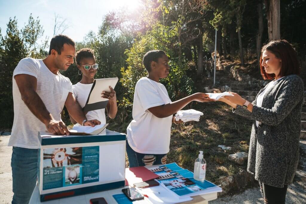 Nonprofit marketing efforts by people handing out flyers to by-passers.